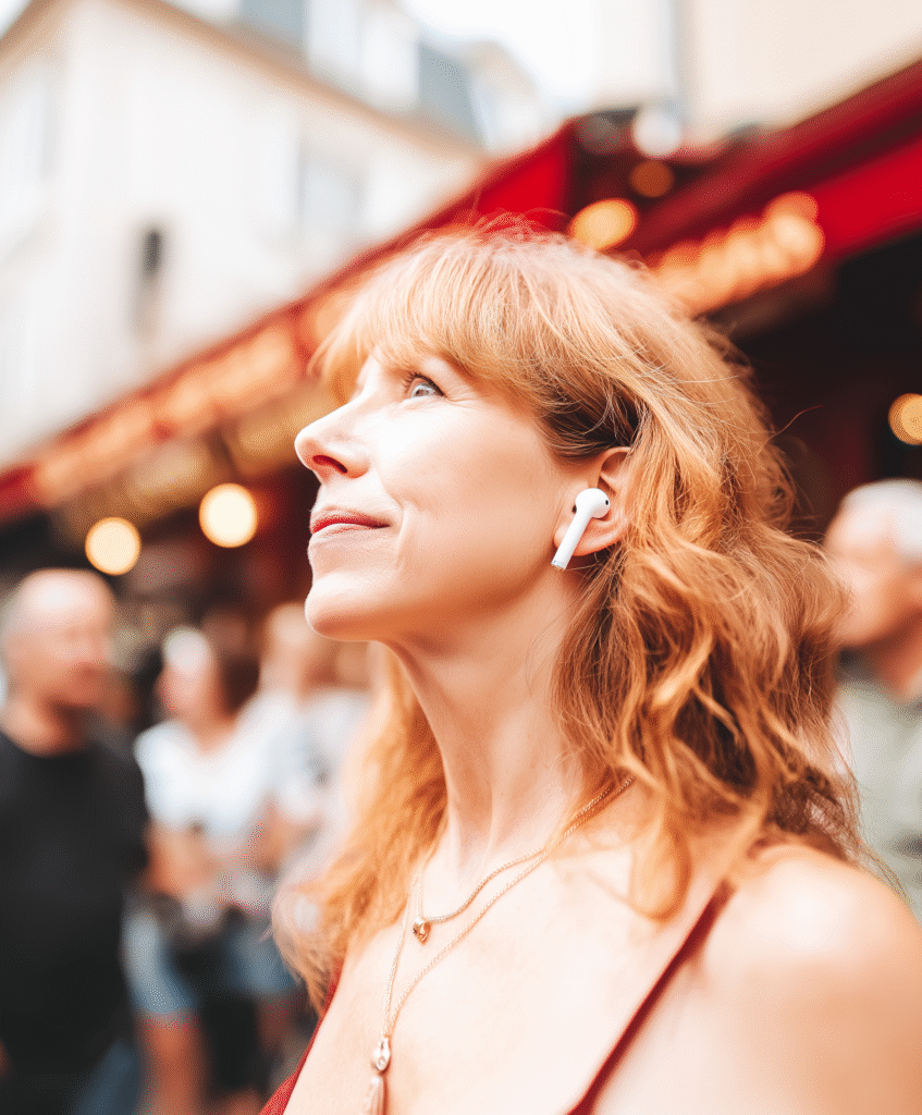 Red-haired woman using WT2 earbuds on the street